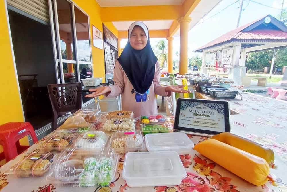 Seorang kakitangan di Hub Makanan Vendor @ Pintu Gerbang Homestay Lonek menunjukkan Meja Infaq Ramadan 2024.