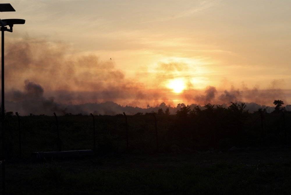 Cahaya matahari ditutupi asap kebakaran hutan dekat Pekan Papar pada Rabu lepas. Foto Bernama