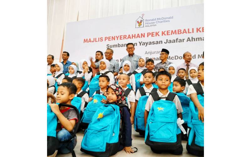 Penasihat YJA, Zainudin Jaafar (belakang, dua dari kanan) bersama Datuk Azmir Jaafar iaitu Presiden Persatuan Kebajikan Ronald McDonald Malaysia (RMHC Malaysia) (tiga dari kanan) bersama-sama murid-murid yang menerima Pek Kembali Ke Sekolah. 