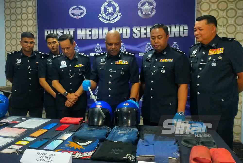 Anbalagan (tengah) menunjukkan barangan kes yang dirampas daripada kes ragut di Bandar Puchong Jaya, Selangor baru-baru ini.
Foto: HISYAMUDDIN AYUB.