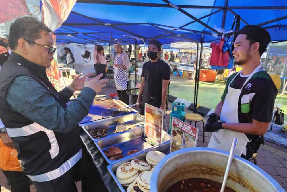 Asits (kiri) membuat tinjauan di Bazar Ramadan Lintasan Deasoka, Kota Kinabalu.