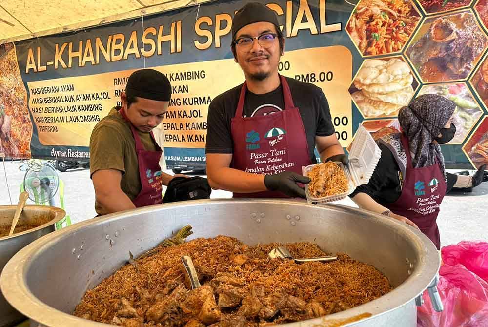 Mohd Fazran menunjukkan nasi beriani berlauk ayam yang dikekalkan harganya sejak tiga tahun lepas.