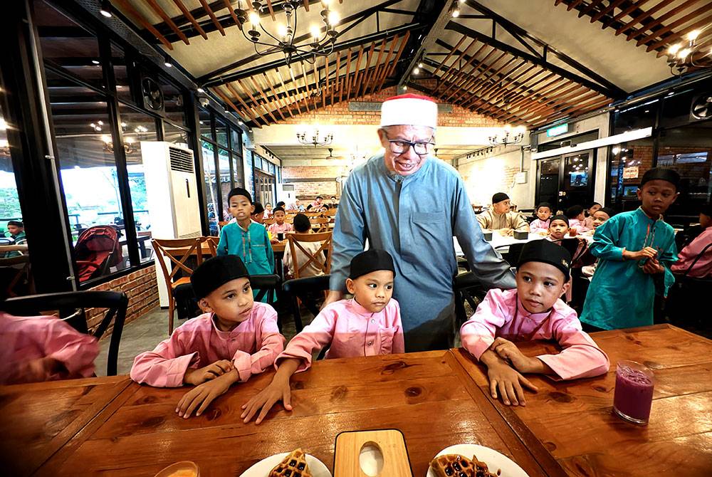 Zulkifli beramah mesra dengan anak-anak yatim yang diraikan.