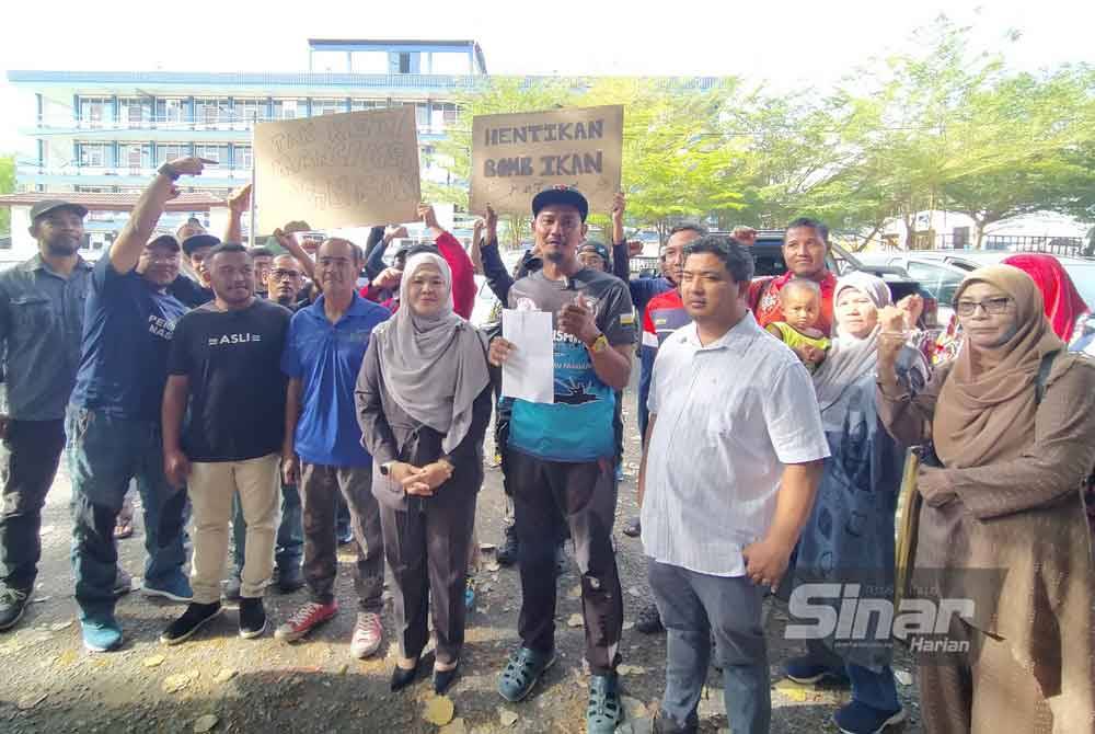 Salbiah (empat dari kanan) dan Fathul Huzir (dua dari kanan) bersama komuniti pemancing yang hadir di hadapan IPD Gerik pada Sabtu.