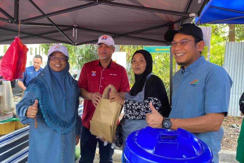 Aiman Athirah menyampaikan cenderamata kepada peniaga Bazar Ramadan Kosmopleks, Bandar Salak Tinggi pada Ahad.