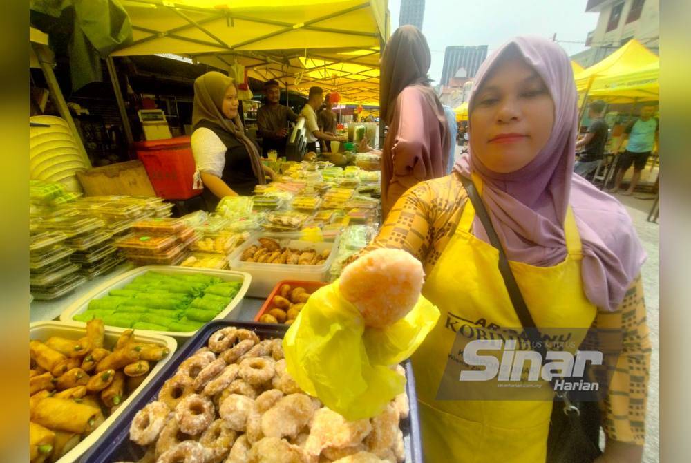 Suriyani menunjukkan kuih getas yang dijual di bazar Ramadan Jalan Raja Alang, Kuala Lumpur.