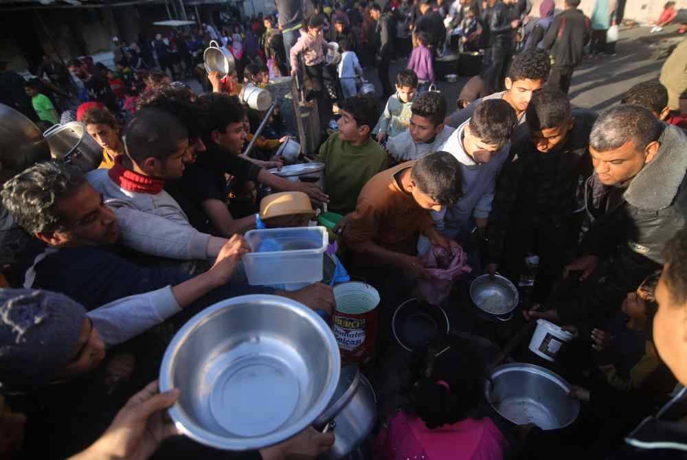 Orang ramai berkumpul untuk mdapatkan bantuan makanan di bandar Rafah di selatan Semenanjung Gaza pada Jumaat. Foto Xinhua