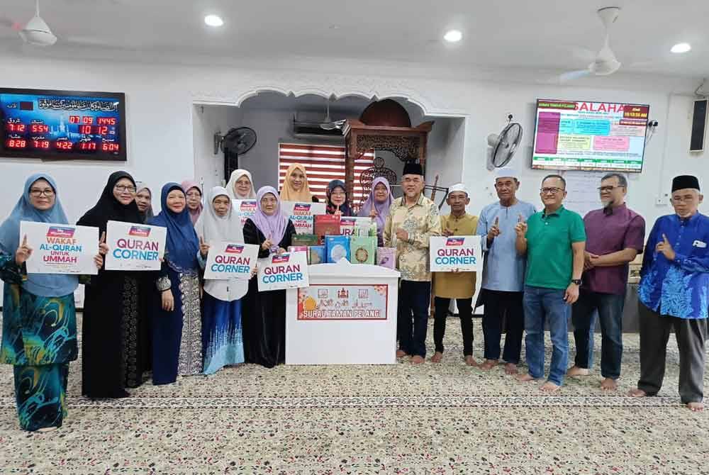 Hashim (enam dari kanan) menyampaikan set al-Quran percuma untuk tujuh masjid, surau dan pejabat sekitar Kluang di Surau Taman Pelangi, Kluang pada Ahad