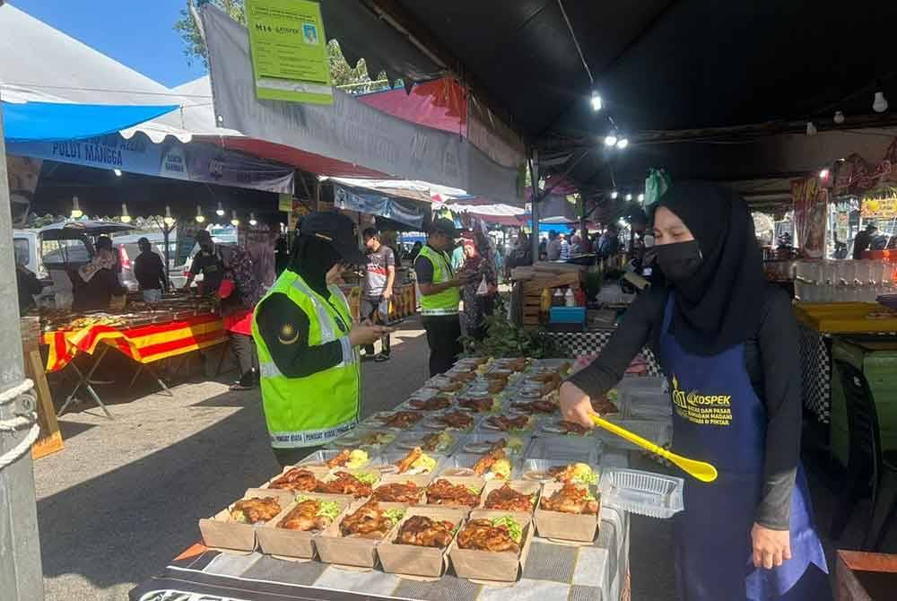 Anggota penguat kuasa KPDN Pahang melakukan pemeriksaan ke atas salah sebuah bazar Ramadan dalam Ops Pantau 2024 di negeri ini.