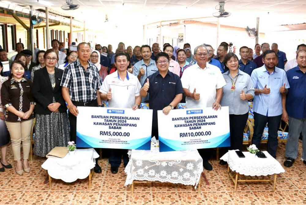 Ewon (enam dari kanan) Philip (lima dari kanan) bersama pihak pengurusan ketika Majlis Penyerahan Sumbangan Sekolah-sekolah di Sabah