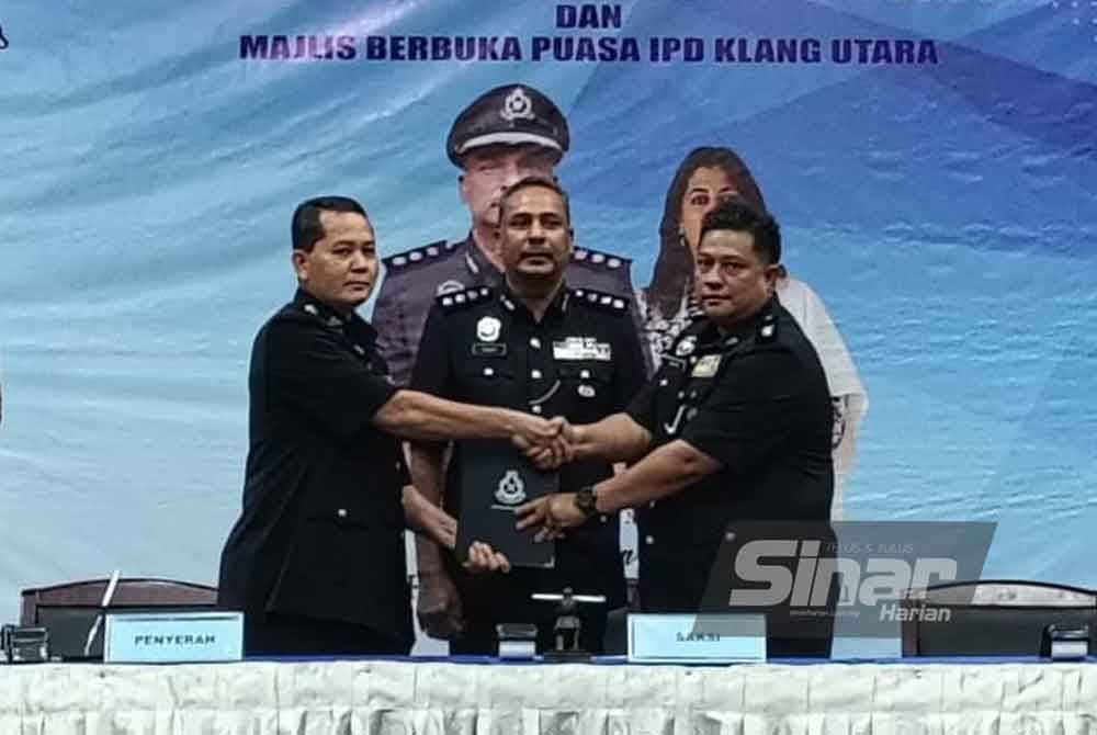 Vijaya (tengah) menyaksikan penyerahan tugas Timbalan Ketua Polis Daerah Klang Utara antara Mohd Khairi (kiri) kepada Mohd Rahimi di Kelab Kilat Pangsapuri TNB, Klang, Selangor pada Selasa.