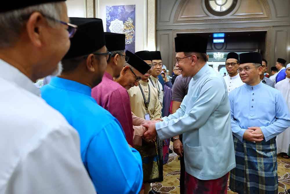 Anwar (dua dari kanan) beramah mesra bersama para tetamu yang hadir pada Majlis Berbuka Puasa Madani Perdana Menteri bersama Para Ilmuwan dan Agamawan di Kompleks Seri Perdana malam ini. Turut kelihatan Menteri di Jabatan Perdana Menteri, (Hal Ehwal Agama) Datuk Dr Mohd Na&#039;im Mokhtar (kanan). Foto Bernama