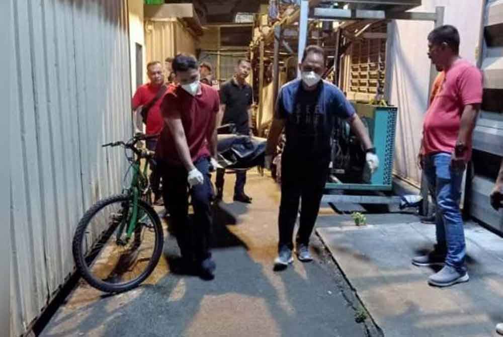 Anggota polis membawa keluar mayat mangsa yang mati ditikam oleh rakan sekerjanya ketika berbuka puasa di asrama pekerja sebuah kilang di Seksyen 36, Shah Alam, Selangor pada Selasa.