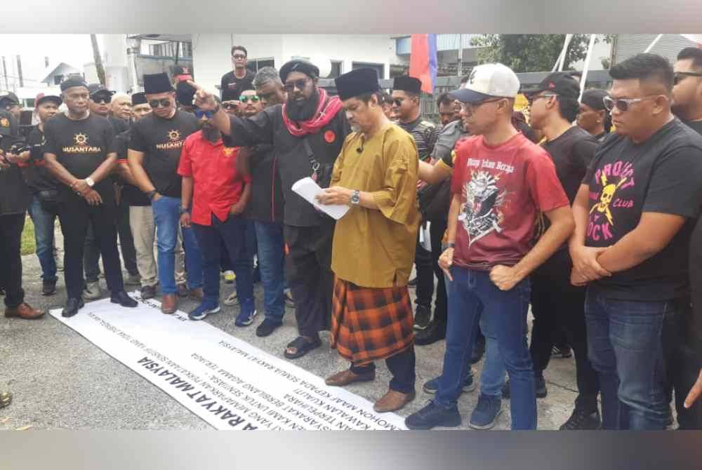 Firdaus (empat dari kanan), Mohd Khan (tiga dari kanan) dan lebih 50 anggota daripada 10 NGO mengadakan perhimpunan aman di hadapan Kilang Xin Jian Chang Sdn Bhd di Kawasan Perindustrian Sri Gading, Batu Pahat pada Rabu.