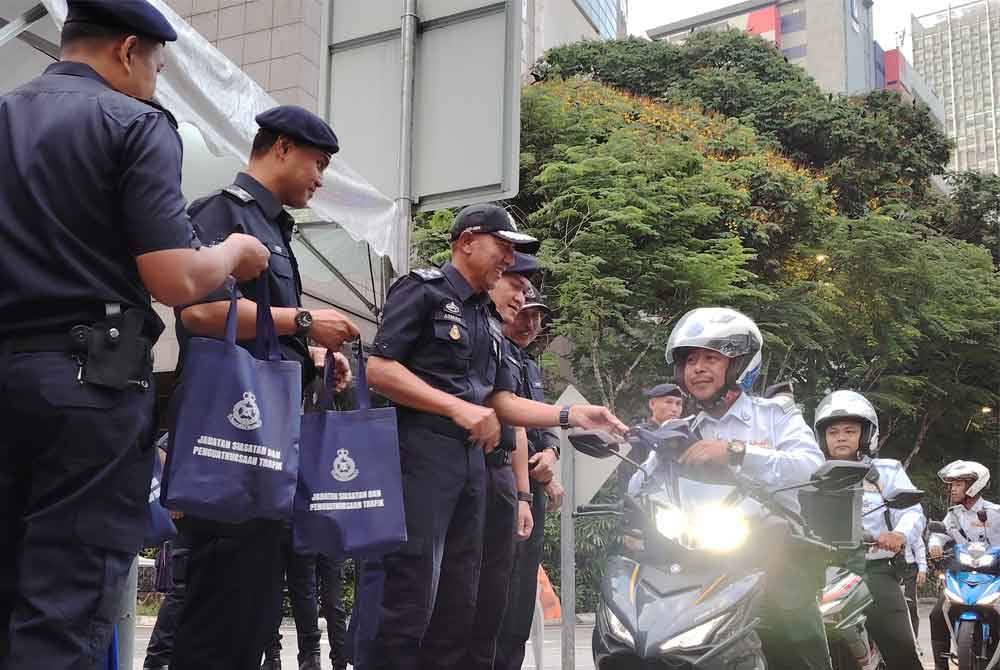 Mohd Azman menyantuni anggota trafik bertugas di Kuala Lumpur, pada Rabu.