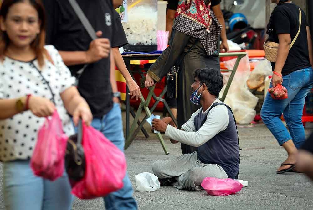 Pengemis warga asing (duduk) menjalankan aktiviti meminta sedekah di Bazar Ramadan Jalan Raja Alang Kampong Baru baru-baru ini.