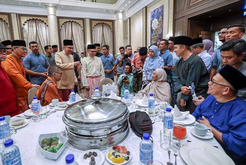 Anwar dan Fahmi Fadzil bersama wartawan veteran dan bekas pengamal media uzur yang menerima bantuan Tabung Kasih@HAWANA semasa majlis Berbuka Puasa MADANI bersama pengamal media di Kompleks Seri Perdana malam Rabu. Foto Bernama