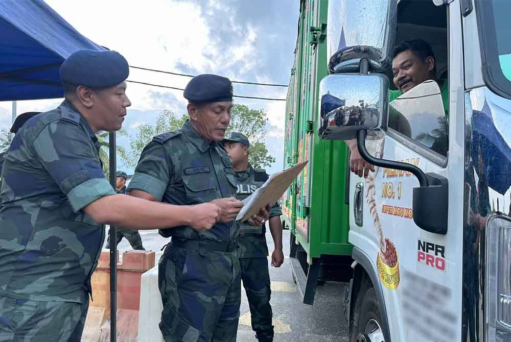 Sheik Azhar (dua dari kiri) memeriksa kenderaan di laluan SJR Cabang Empat Salam di Rantau Panjang.