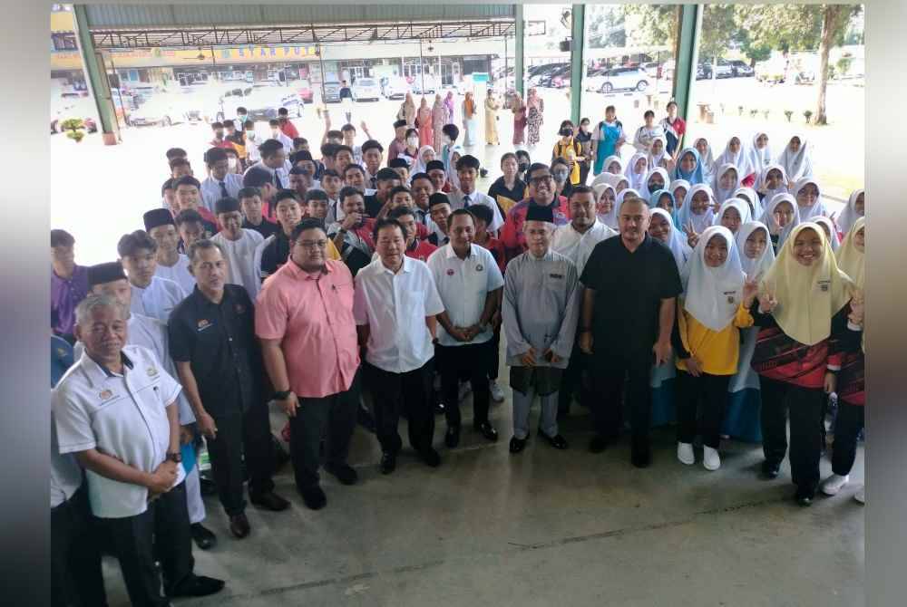 Aznan (tengah) bergambar bersama guru di SMK Tunku Abdul Rahman Putra pada Khamis.