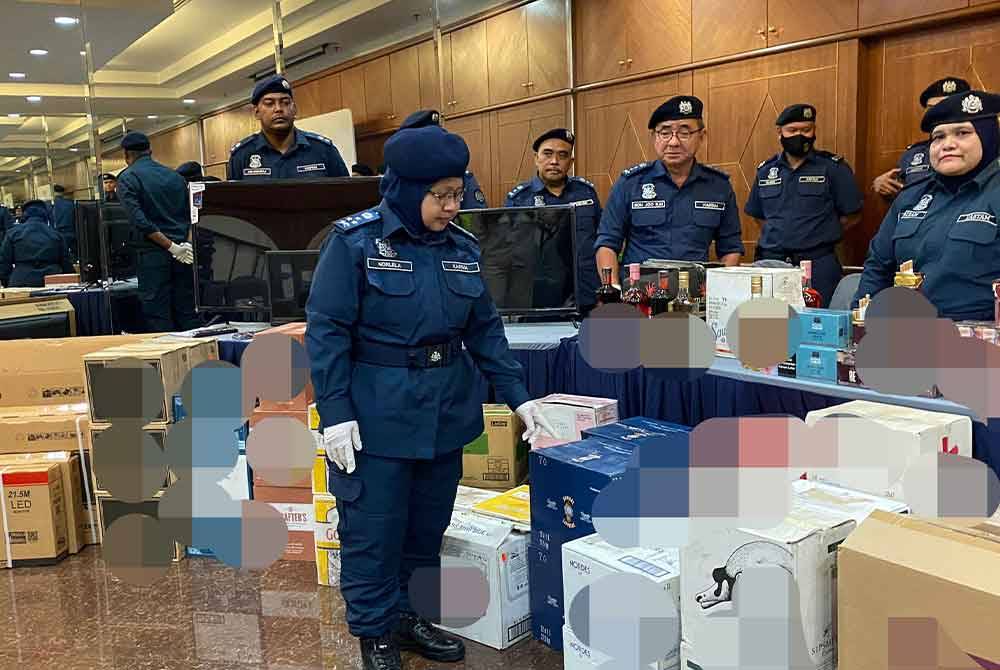 Norlela menunjukkan antara minuman keras dipercayai tidak bercukai dirampas menerusi serbuan di sebuah rumah di Jalan Terasek, Bangsar Baru, 6 Mac lalu.