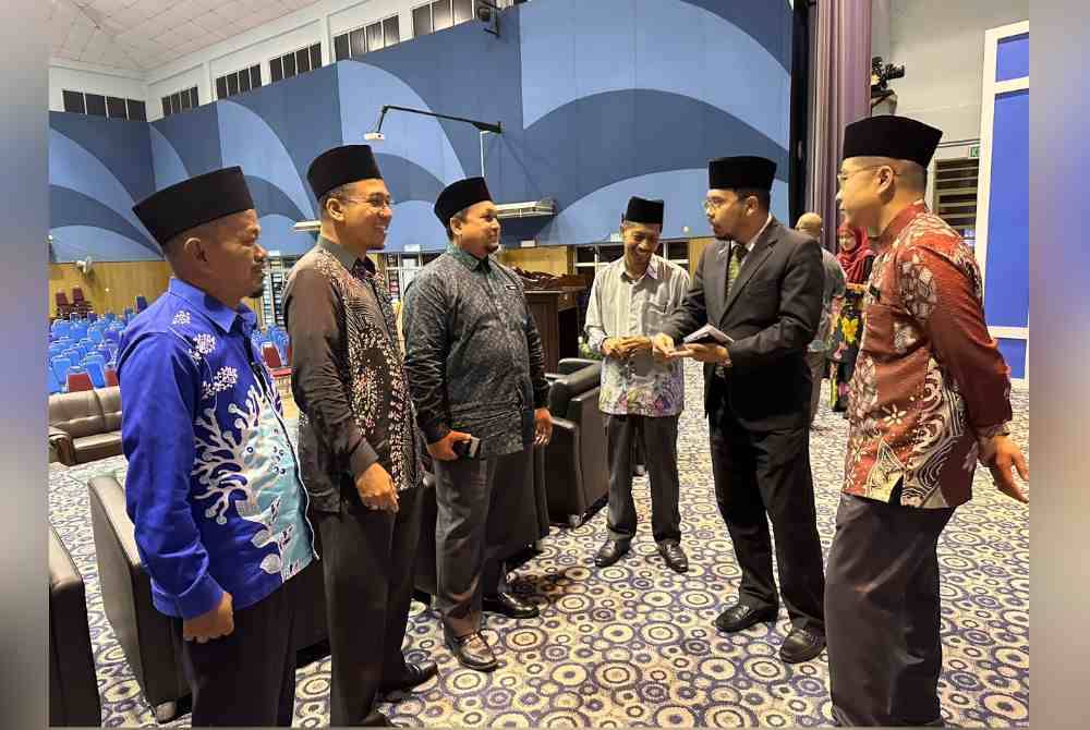 Nik Saiful Adli (dua dari kanan) berbual bersama Zamri (tiga dari kiri) dan kakitangan Yadim pada Forum Pengukuhan Kedudukan Mahkamah Syariah di Malaysia di Tunjong di Kota Bharu pada Khamis.