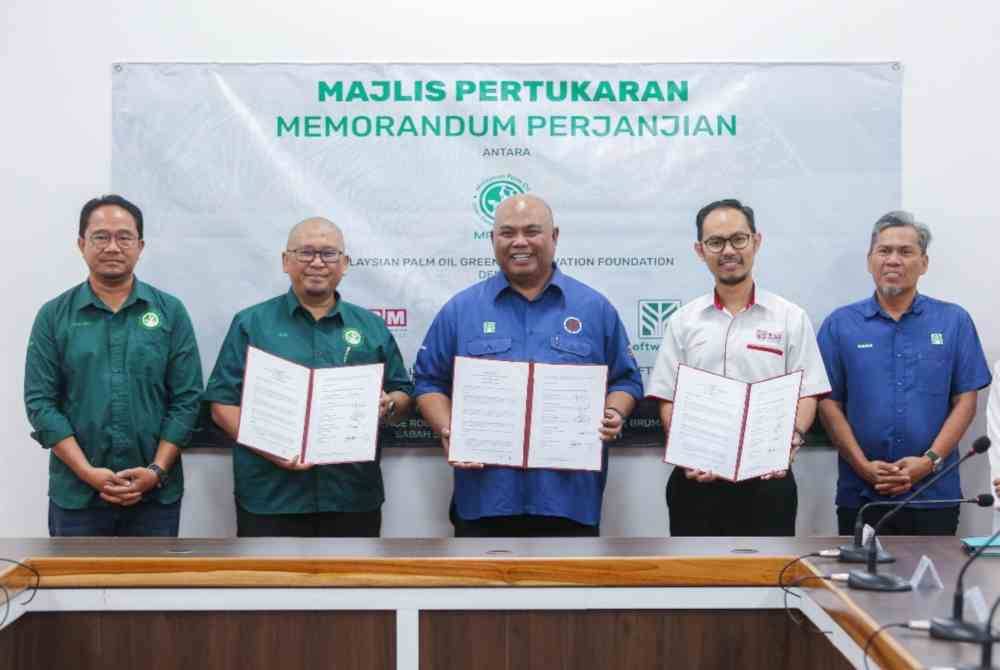 Hairulazim (dua dari kiri); Mohd Daud (tengah) dan Dr Anjas Asmara (dua dari kanan) pada majlis pertukaran MoA di Pejabat Penanaman Pokok Pusat Sabah Softwoods Berhad di Brumas, Tawau, Sabah pada Khamis.