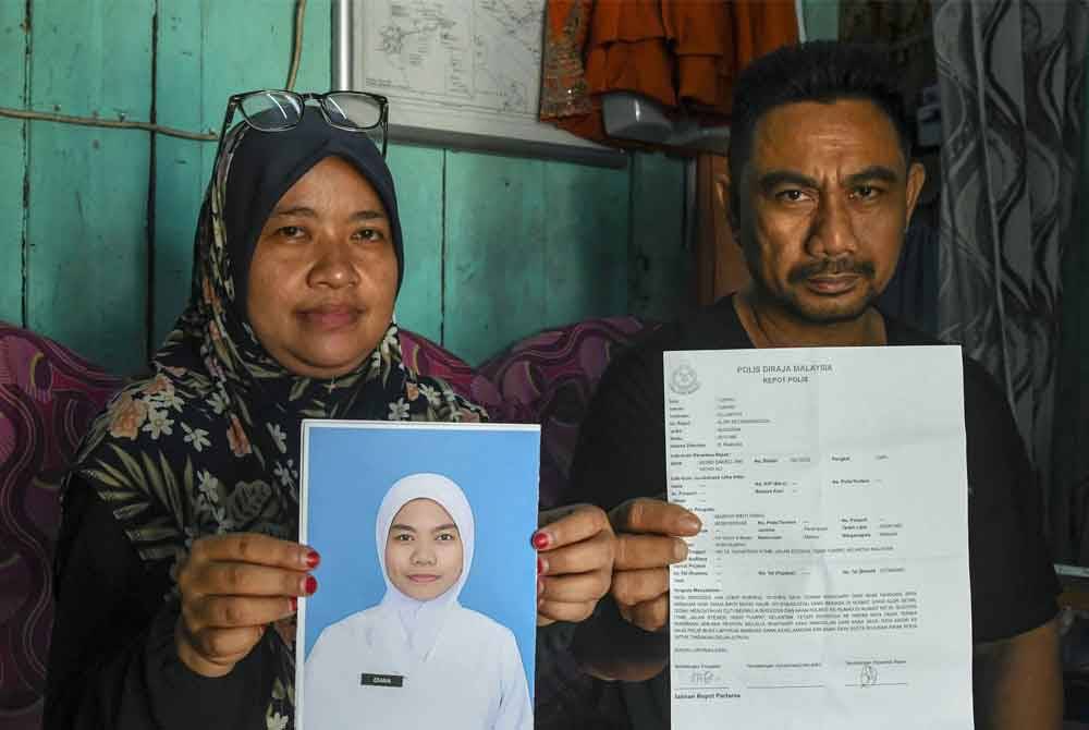 Maznah (kiri) bersama suami menunjukkan gambar dan laporan polis yang dibuat berkenaan anaknya Nor Diana yang didakwa hilang sejak 29 Februari lalu ketika ditemui pemberita di Kuarters Keretapi Tanah Melayu Berhad (KTMB) Jalan Stesen Keretapi Tumpat - Foto: Bernama