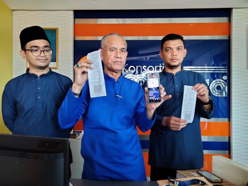 Che Ibrahim (tengah) menunjukkan tiket yang boleh didapati pelanggan.