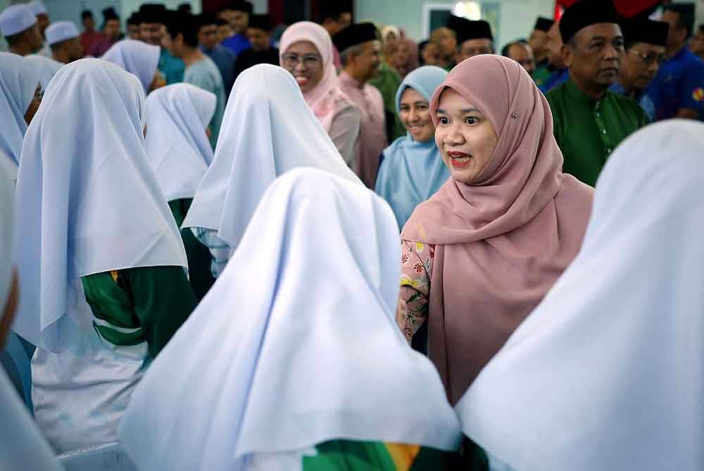 Fadhlina meluangkan masa beramah mesra bersama pelajar-pelajar semasa hadir pada majlis Perasmian Program Hijrah Kasih di Sekolah Henry Gurney Telok Mas hari ini. - Foto: Bernama