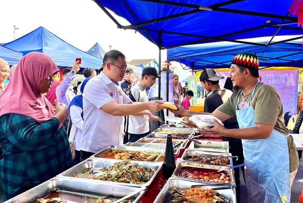 Tian Soon (tengah) beramah mesra dengan peniaga semasa Program Walkabout dan Lawatan ke Premis di Bazar Ramadan Taman Universiti, Skudai Johor Bahru pada lewat petang Khamis.