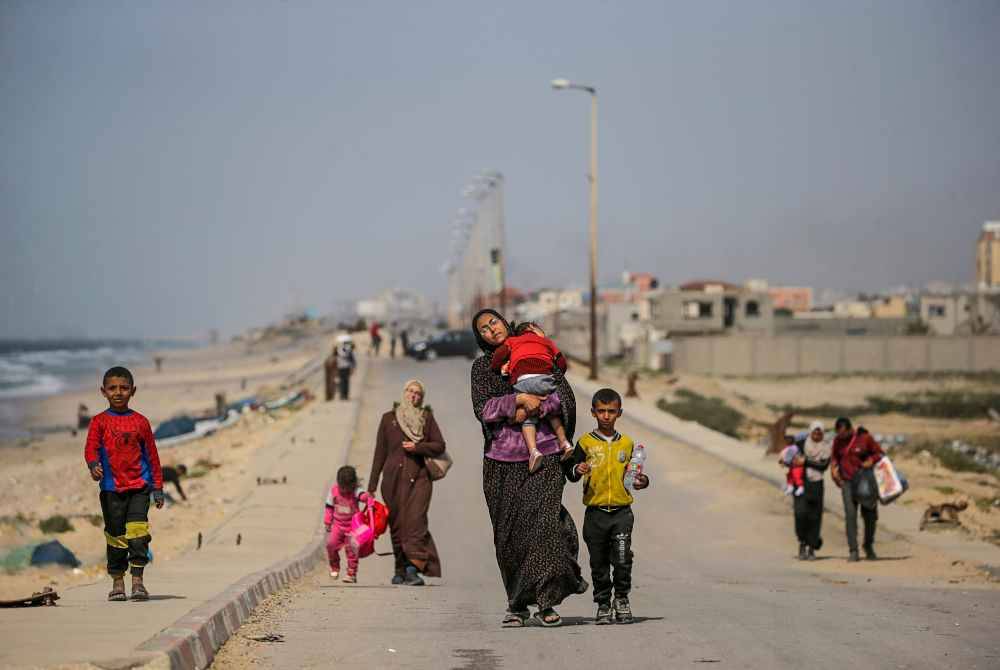 Rakyat Palestin, termasuk wanita dan kanak-kanak, menyeberang dari utara ke selatan Gaza berjalan di sepanjang jalan Al Rashid, Semenanjung Gaza pada Khamis. Foto EPA