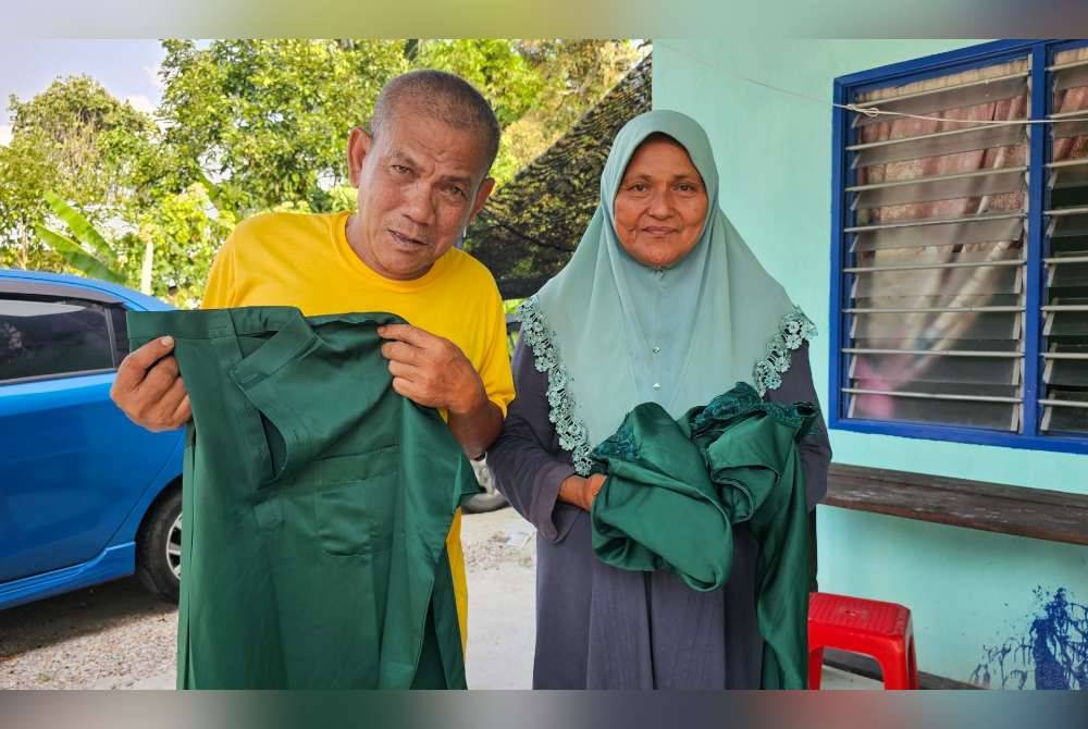 Noor Asmah bersama suaminya, Dek Kamil menunjukkan baju raya yang dibeli Nurrul Anisah sebelum terlibat dalam kemalangan jalan raya pada 10 Mac lalu.