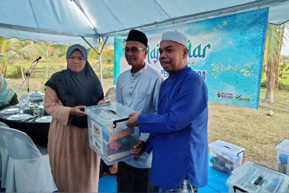 Muhammad (tengah) menyampaikan bakul makanan kepada asnaf pada Majlis Iftar Bersama Pengerusi KADA di kediaman beliau pada Jumaat.