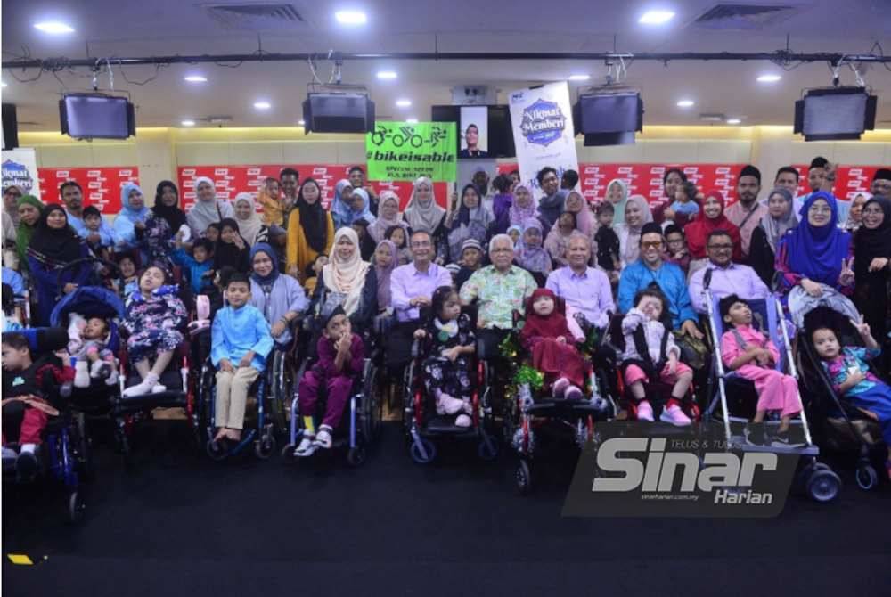 Mohammed dan Hussamuddin (tengah) bergambar bersama warga PPZ-MAIWP, pengurusan Kumpulan Karangkraf, MyCP dan Bikeisable di Kompleks Kumpulan Karangkraf pada Khamis.