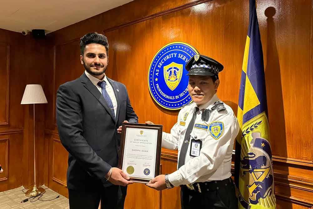 Pengarah A5 Security Service, Hardeep Singh Jaswant (kiri) menyampaikan sijil penghargaan kepada Dawa dalam satu majlis ringkas di pejabatnya. FotoSyarikat A5 Security Services