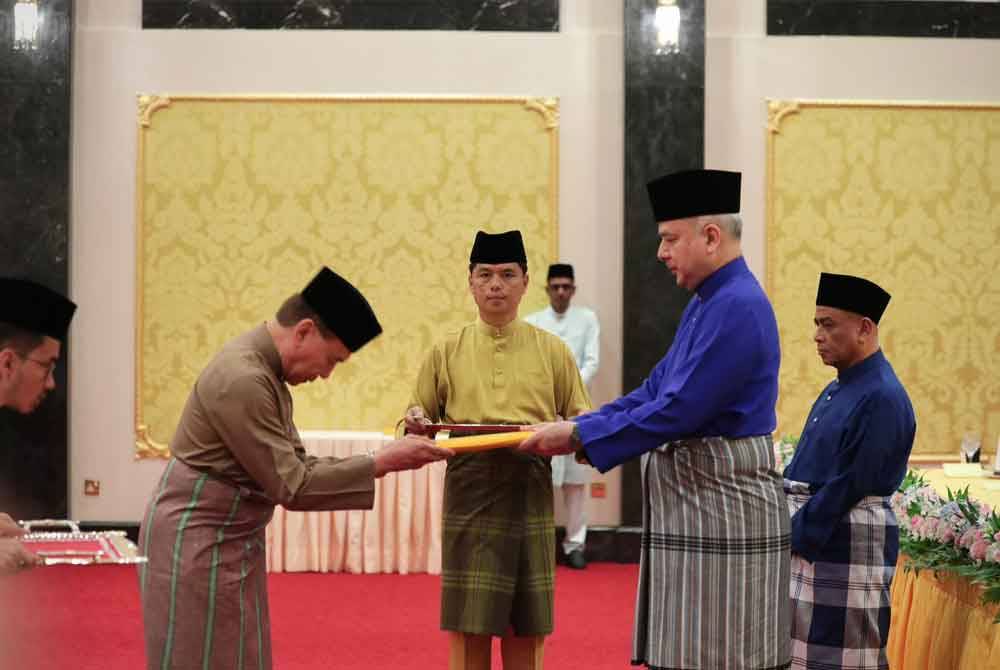 Sultan Nazrin (kanan) menyerahkan terimaan zakat perniagaan kepada Mohd Annuar di Istana Iskandariah di sini pada Sabtu. Foto Pejabat MB Perak.