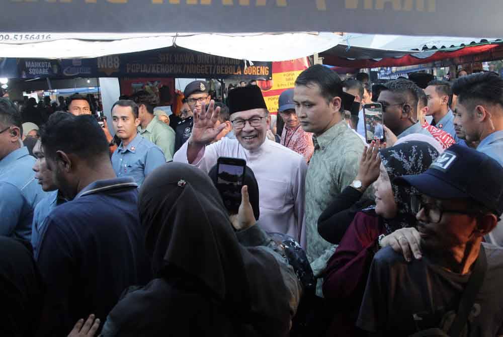 Perdana Menteri Datuk Seri Anwar Ibrahim menyantuni orang ramai semasa meluangkan masa kira-kira sejam mengunjungi Bazar Ramadan Mahkota Square pada Sabtu. Foto Bernama