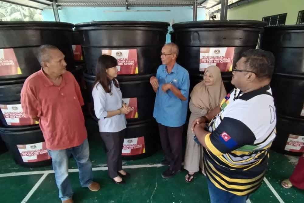 Surono (tiga dari kiri), berkata sesuatu kepada Nie Ching selepas menerima tangki air berkenaan.