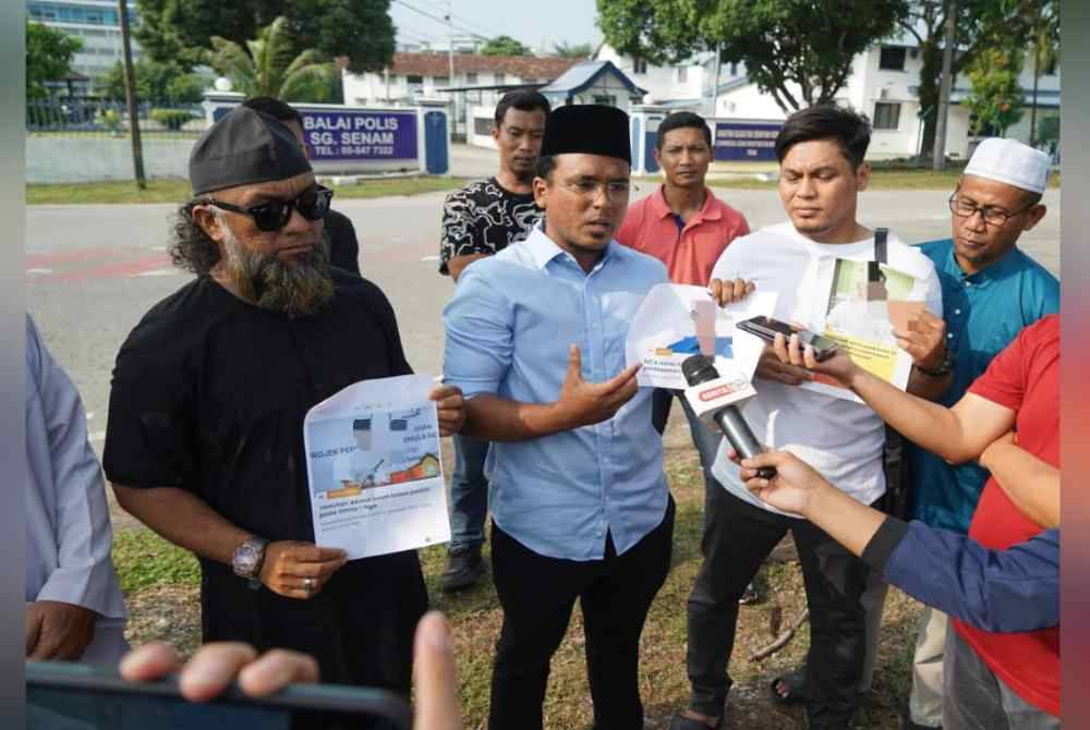 Yushairil Iswan (tengah) bersama beberapa wakil NGO menunjukkan gambar keratan kenyataan beberapa pemimpin yang didakwa memperlekeh usaha boikot kepada pemberita di hadapan Balai Polis Sungai Senam di sini pada Ahad.