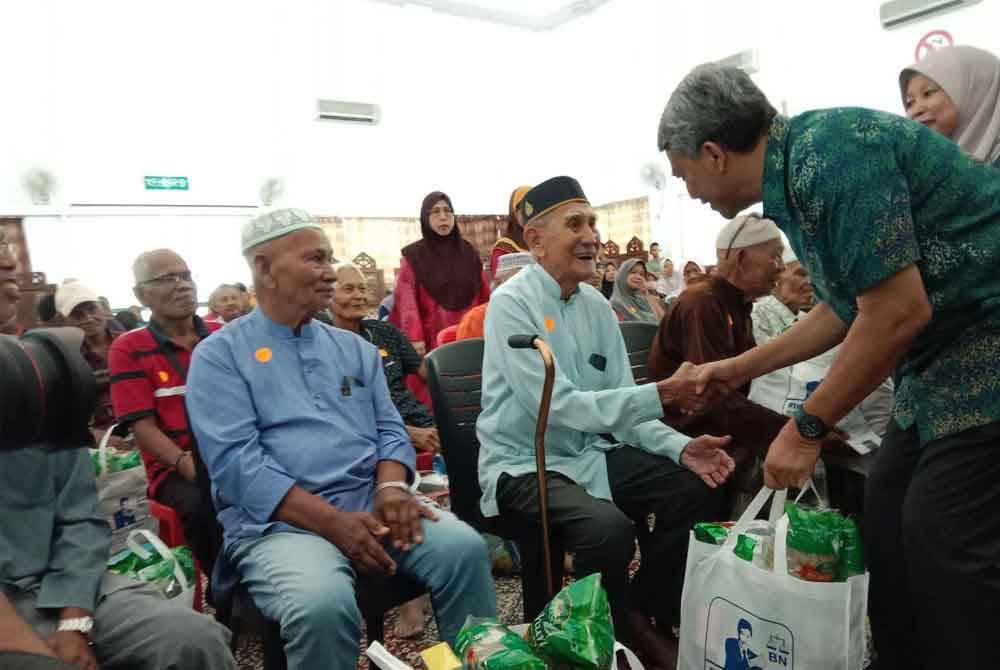 Mohamad (kanan) ketika menyampaikan sumbangan berkenaan pada Ahad.