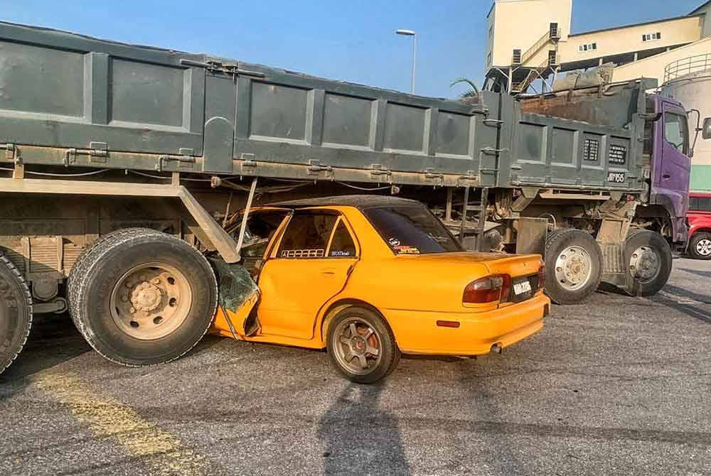 Kereta yang dipandu mangsa terperosok di bawah treler dalam kemalangan maut di kawasan Perindustrian Lipat Kajang, di sini, pada Isnin.