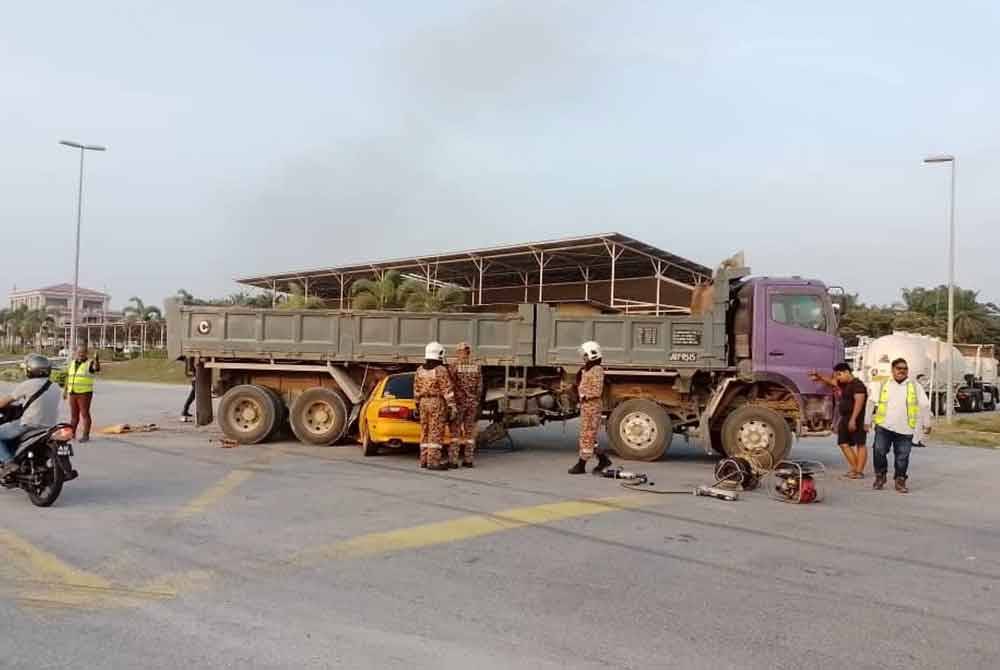 Kereta dipandu mangsa terperosok bawah treler dalam kemalangan maut di Kawasan Perindustrian Lipat Kajang, di sini, pada Isnin. Foto JBPM