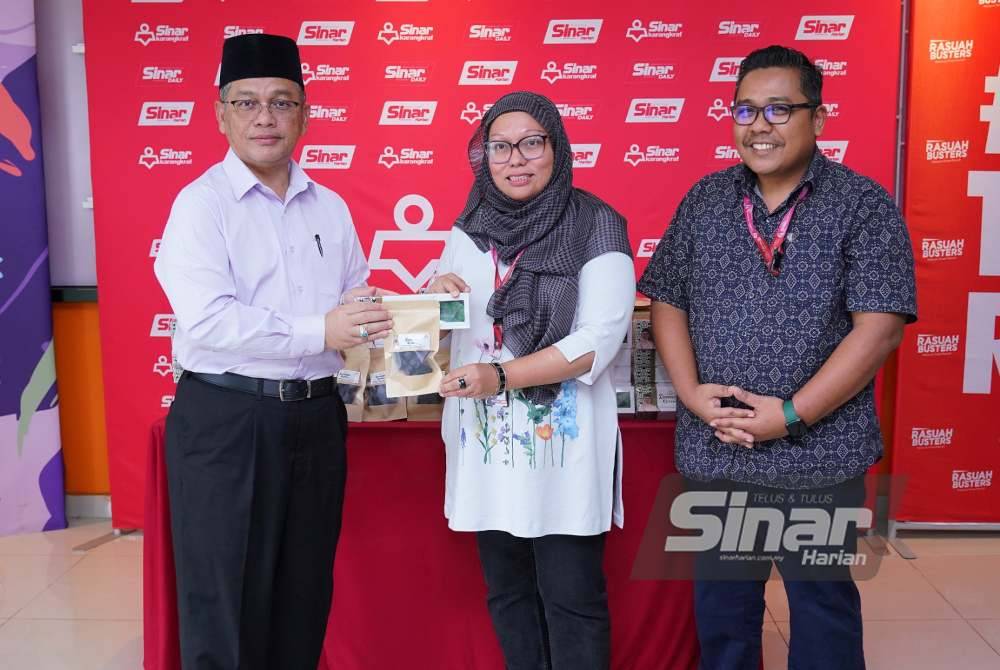 Mohd Na&#039;im (kiri) menyampaikan sumbangan kurma dan buah-buahan kering kepada Firdaus ketika ziarah Ramadan ke Kumpulan Karangkraf pada Isnin. Turut bersama Zamri. Foto SINAR HARIAN / MOHD HALIM ABDUL WAHID