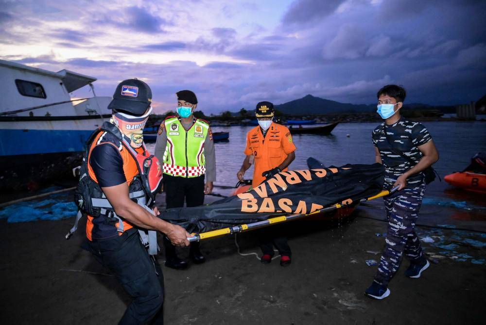 Anggota Badan Mencari dan Menyelamat Kebangsaan (BASARNAS) membawa mayat yang ditemui semasa operasi mencari pelarian Rohingya. Foto AFP