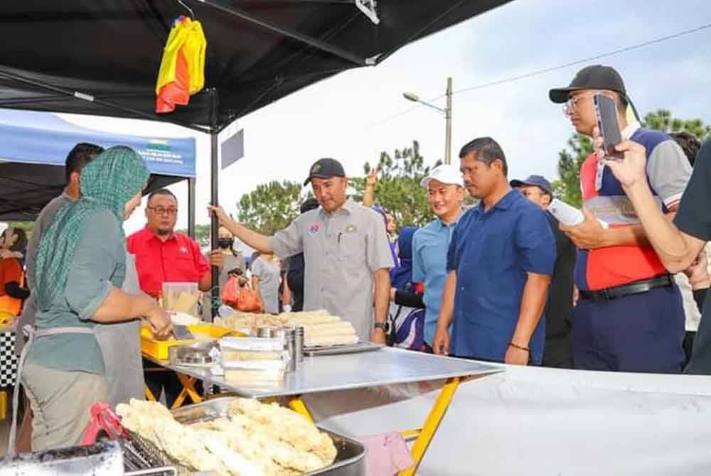 Mohd Jafni (empat dari kanan) menyantuni peniaga di Bazar Ramadan Jalan Enggang, Kulai, pada lewat petang Ahad