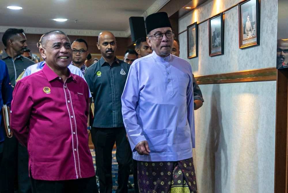 Anwar (kanan) disambut Saarani (kiri) ketika menghadiri pertemuan bersama anggota kerajaan negeri di Bangunan Perak Darul Ridzuan pada Isnin.