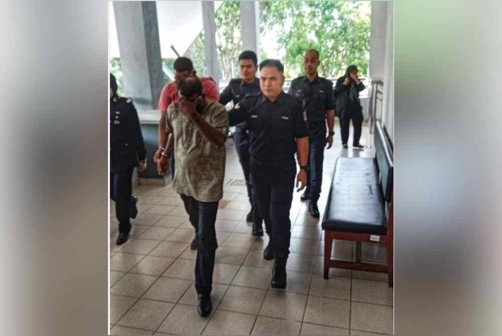 Tertuduh ketika diiringi polis tiba di mahkamah.