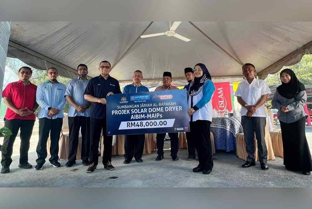 Penyerahan sumbangan projek Kubah Pengering Solar oleh Ketua Pegawai Syariah Bank Rakyat, Mohd Zamerey Abdul Razak (empat, kiri) untuk manfaat masyarakat di Pulau Ketam.