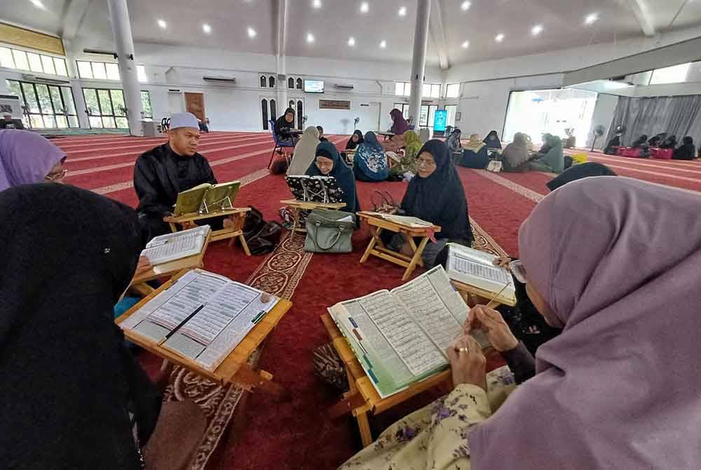 Mohd Hanifah (tiga dari kiri) mendengar bacaan daripada pelajarnya ketika bertadarus di Masjid Tengku Ampuan Afzan, Indera Mahkota, Kuantan.