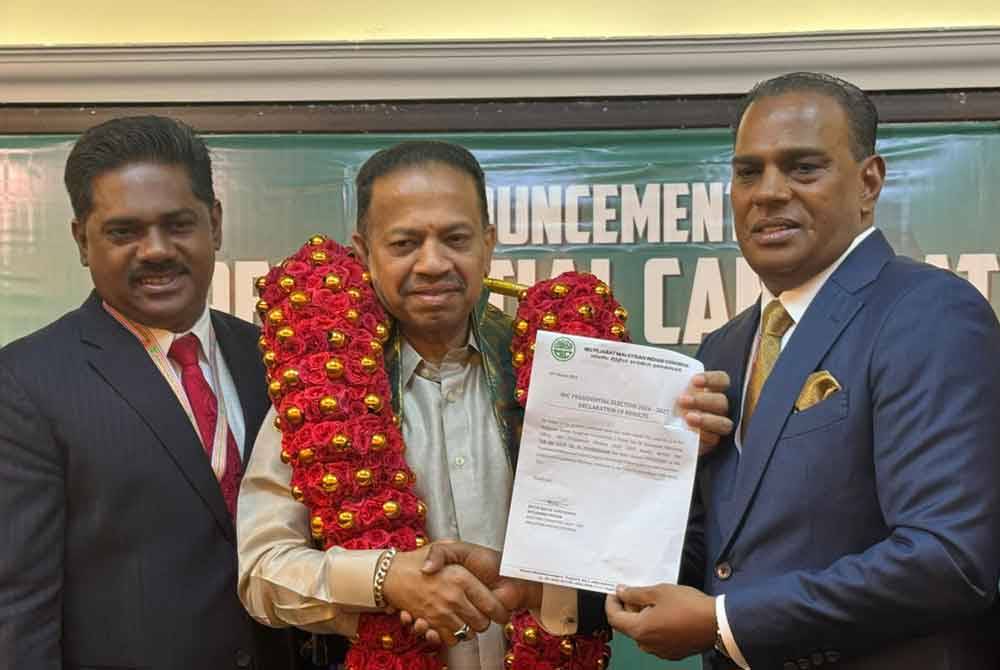 Vigneswaran (tengah) menerima surat deklarasi daripada M Saravanan (kanan) selepas diumumkan kekal sebagai Presiden parti berkenaan pada Rabu.